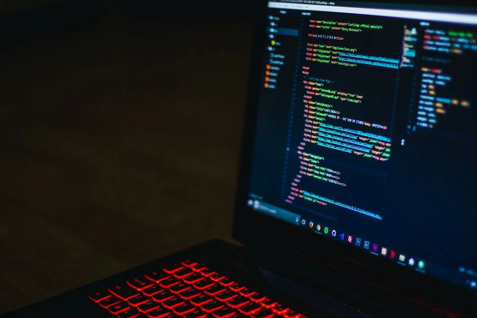 Close-up of hands typing on a laptop next to a cup of coffee on a wooden desk.